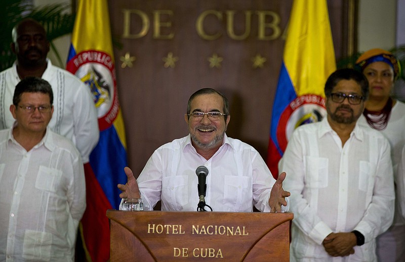 
              Commander of the Revolutionary Armed Forces of Colombia or FARC, Rodrigo Londono, better known as Timochenko or Timoleon Jimenez talks to the press, accompanied by Ivan Marquez, right, chief negotiator of the Revolutionary Armed Forces of Colombia and Pablo Catatumbo, left, chief of the FARC's western bloc, in Havana, Cuba, Sunday, August 28, 2016. The commander of Colombia's biggest rebel movement says its fighters will permanently cease hostilities with the government beginning with the first minute of Monday, as a result of their peace accord for ending five decades of war. (AP Photo/Ramon Espinosa)
            