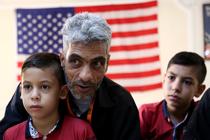 
              AMMAN, Jordan _ In this photo taken Sunday, August 28, 2016, Syrian refugee Nadim Fawzi Jouriyeh, 49, speaks to reporters at the Amman, Jordan office of the International Organization for Migration. Jouriyeh is flanked by his sons Farouq, 8, and Hamzeh, 12. The six-member Jouriyeh family will head to San Diego, California, as part of a year-long program to resettle 10,000 Syrian refugees in the United States.(AP Photo/Raad Adayleh)
            