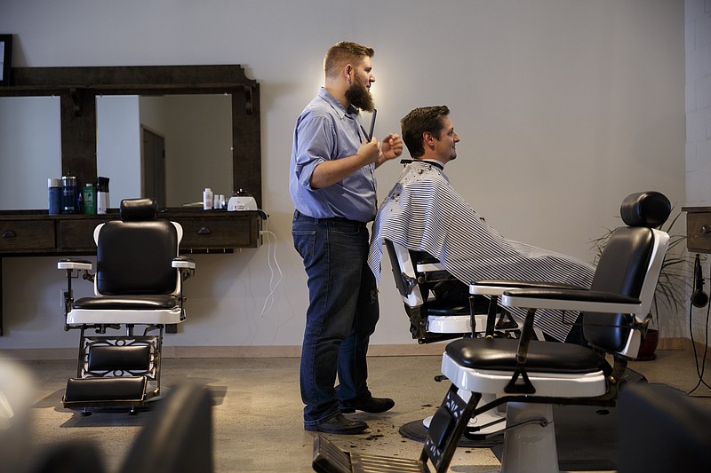 Hunter Watts cuts Will Galbreth's hair at All City Barber Co. on West 20th Street on Thursday, Aug. 4, 2016, in Chattanooga, Tenn.  The barber shop was opened by 23-year-old Kristin Gonzalez.