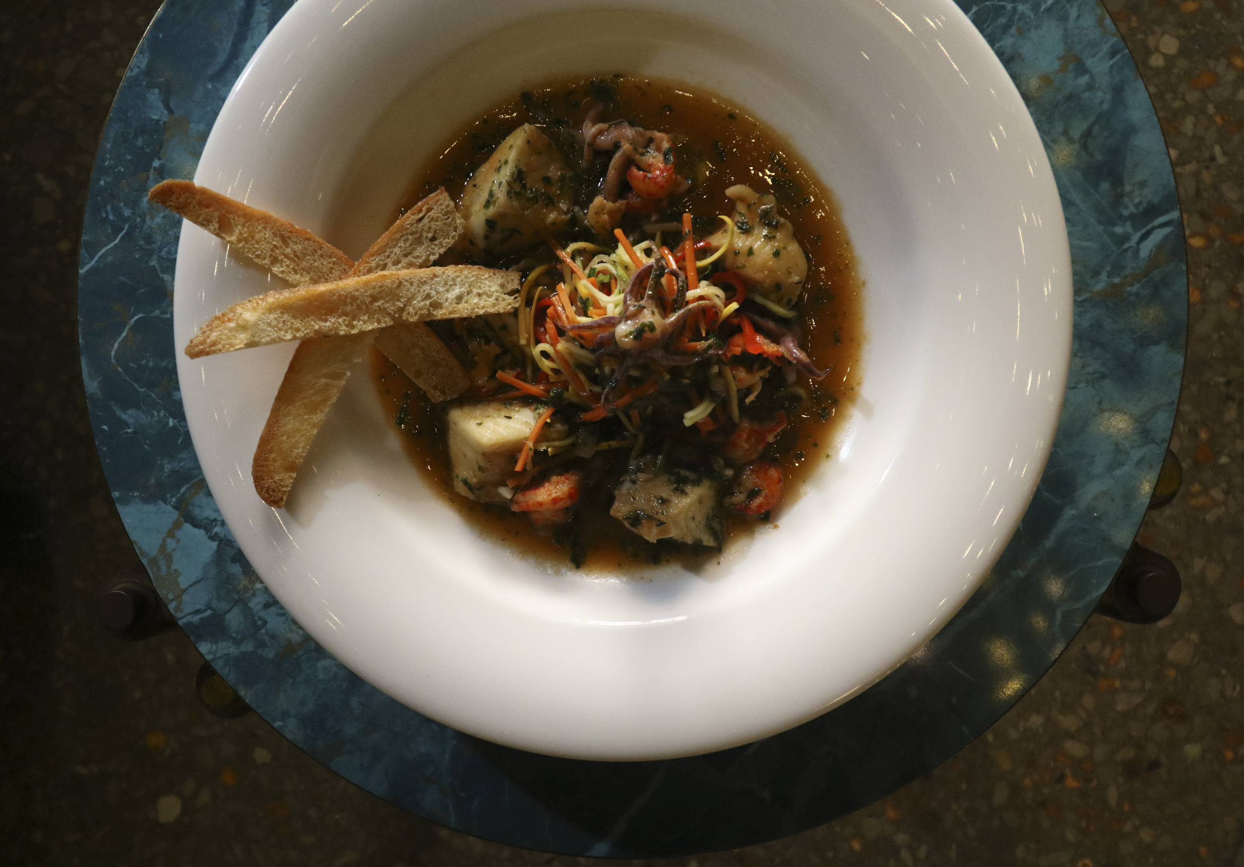 Executive Chef Hardin Cowan presents a Catfish, Squid and Crayfish trio served in a herbaceous lobster broth at Terra Mae on Wednesday, August 17, 2016.