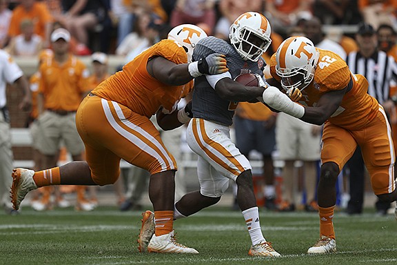 Staff Photo by Dan Henry / The Chattanooga Times Free Press- 4/25/15. The University of Tennessee's Pig Howard (2) gets taken down by defensive players Shy Tuttle (2) and Chris Weatherd (42) during the Dish Orange & White Game in Knoxville on Saturday, April 25, 2015. Final score was Orange 54, White 44.