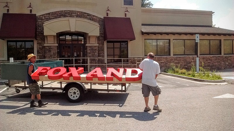 Buddy Ratley, right, and Steve Patrick of Buddy Ratley Signs in Red Bank take down the signage on Monday, August 29, 2016, from the Fox and Hound Pub & Grille near Hamilton Place Mall.