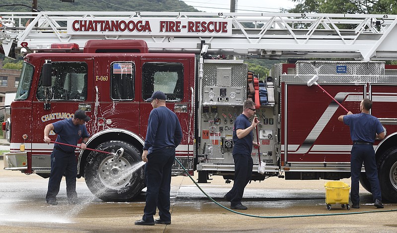 Chad McBryar, Jake Cask, John Long and Mack Ridge of the Chattanooga Fire Department, from left, wash a fire engine at Station 14 on 40th Street on Sunday, Oct. 4, 2015., in Chattanooga.