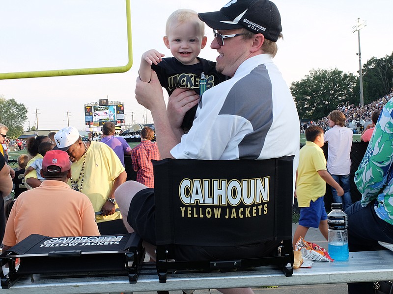 Calhoun fans Brody Pike, 1, and his dad, Josh, enjoy their north end zone seats at Friday night's game with visiting Dalton.