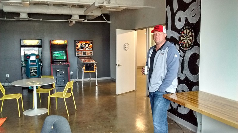 Derek Rogers, owner of Strafire Website Design, drinks a soda in the game room at Society of Work, where he has an office. "I love it," Rogers said, since he's met business people there who've led him to new clients, and Rogers has sent business other tenants' way. Below: A keg of Chattanooga-made The Bitter Alibi beer on tap is seen in the Edney Innovation Center.