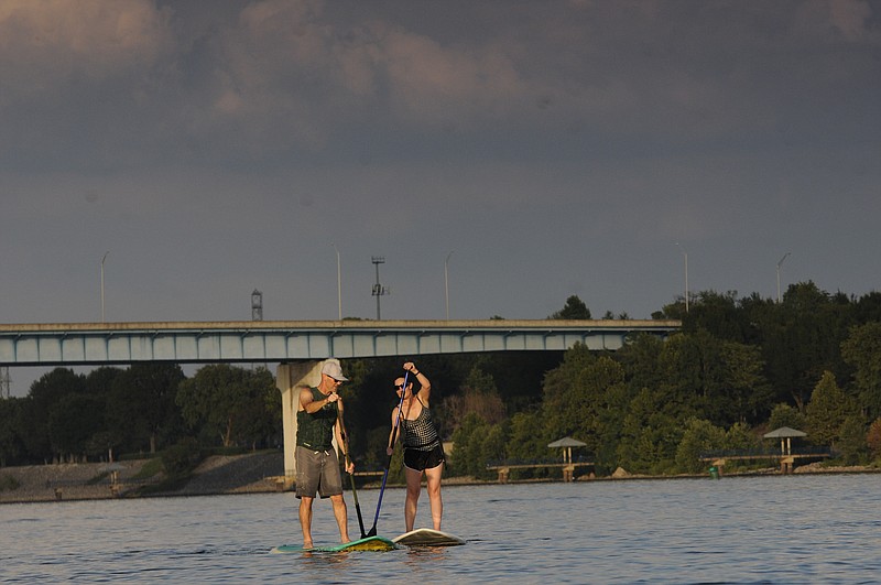 Brent and Renae<cq>Sanders enjoy their stand up paddle boards Wednesday evening on the Tennessee River. "This is about our tenth time out this season," Sanders said. "It's great to see the wildlife like heron otters and fish as we paddle."
The C.B. Robinson Bridge looms in the background above the Hubert Fry Pavilion at the Tennessee Riverpark.