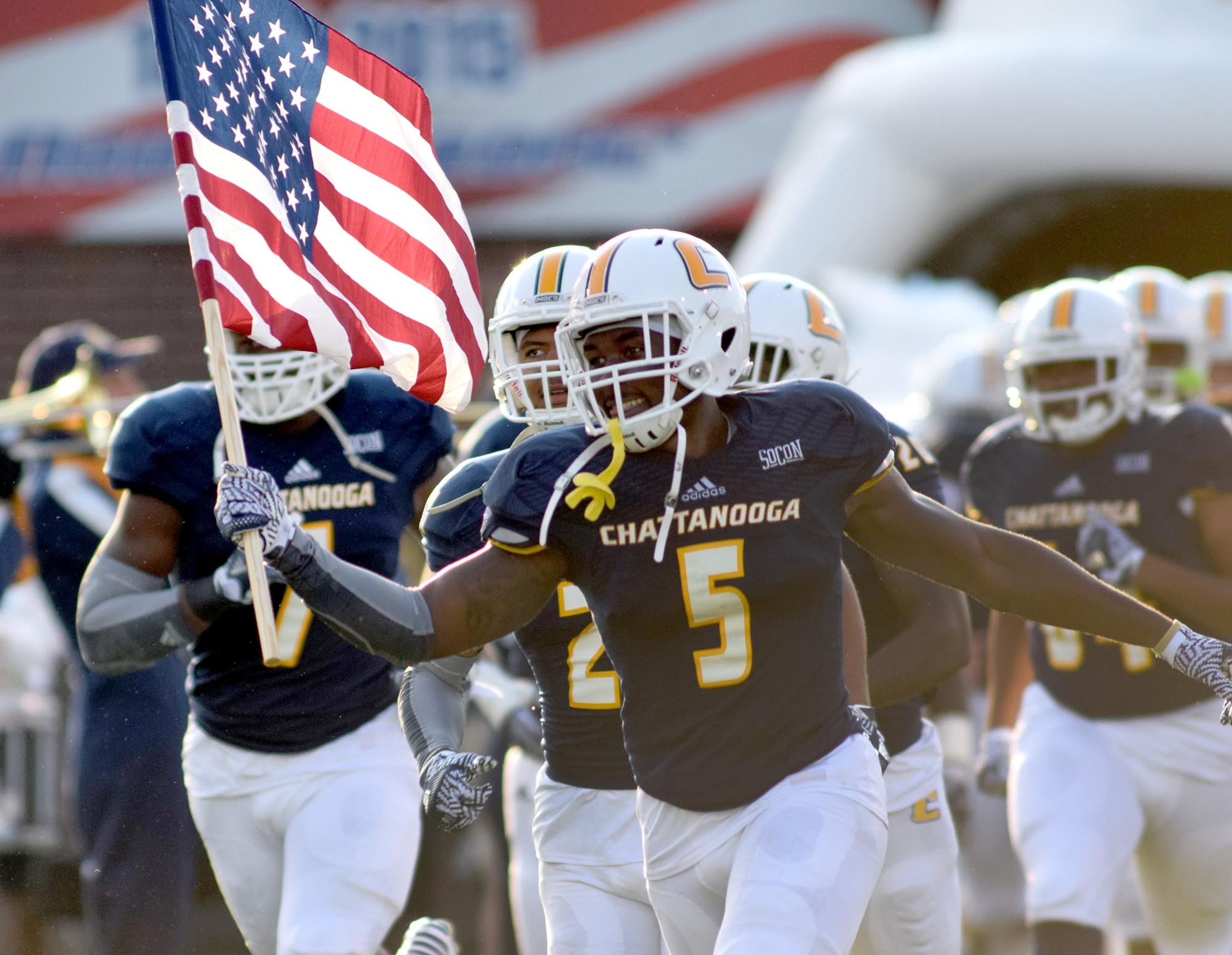 Linebacker Nakevion Leslie (5) carries the United States Flag as he leads the team out. The University of Tennessee/Chattanooga Mocs hosted the Shorter University Hawks in NCAA football action on Sept. 1, 2016.