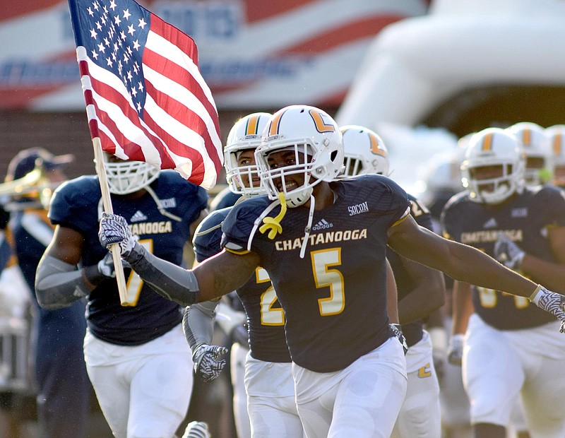 Linebacker Nakevion Leslie (5) carries the United States Flag as he leads the team out.  The University of Tennessee/Chattanooga Mocs hosted the Shorter University Hawks in NCAA football action on Sept. 1, 2016. 