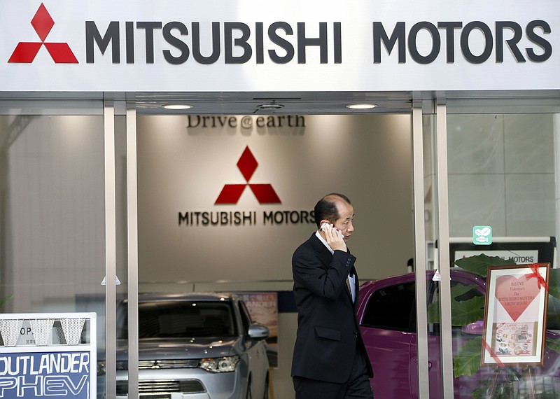 
              FILE - In this Feb . 5, 2013 file photo, a man talking on the mobile phone walks out from the headquarters of Mitsubishi Motors Corp. in Tokyo. Japanese transport ministry officials raided the Tokyo headquarters of scandal-ridden Mitsubishi Motors Corp. Friday, Sept. 2, 2016 after the government alleged the automaker cheated on mileage ratings on more models than earlier reported. (AP Photo/Koji Sasahara, File)
            