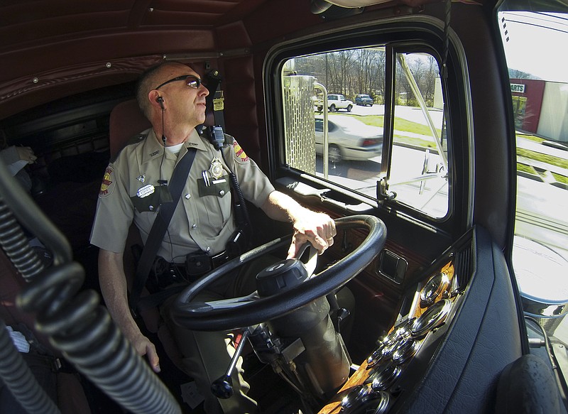 Staff Photo by Dan Henry - 3/14/13. Tennessee State Trooper Gordon Roberts uses the department's "No Zone" semi to spot people texting while driving on Brown's Ferry Road early Thursday afternoon. Roberts relayed the offenders vehicle make and model information to a fellow state troopers who pulled the individuals over for citation. This is the Tennessee Highway Patrol's second day using the 18-wheeler to deter texting and drinking while driving. 