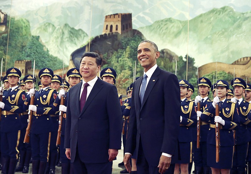 
              FILE - In this Nov. 12, 2014 file photo, U.S. President Barack Obama, right, smiles after a group of children waved flags and flowers to cheer him during a welcome ceremony with Chinese President Xi Jinping at the Great Hall of the People in Beijing, China. As Barack Obama embarks on what is likely to be his final trip to Asia as president, attention is returning to what is known as the U.S. "pivot" to the continent launched during his first term. The policy adjustment aimed to reinforce alliances and shift military assets to a region that has grown in importance alongside the rise of China as a global economic and political power. (AP Photo/Andy Wong, File)
            