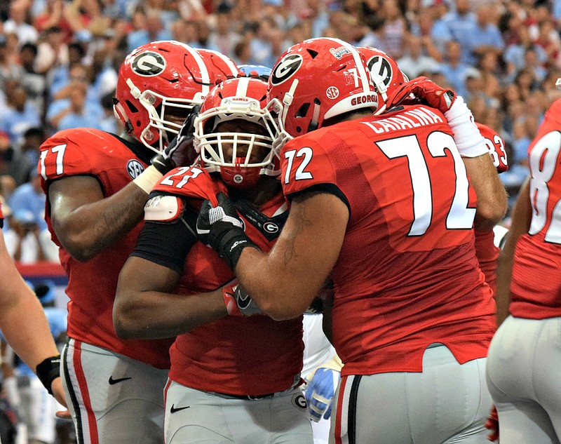 Georgia tailback Nick Chubb celebrates his first touchdown of the season with left guard Isaiah Wynn (77) and left tackle Tyler Catalina (72) during Saturday's 33-24 win over North Carolina in the Chick-fil-A Kickoff Game at the Georgia Dome.