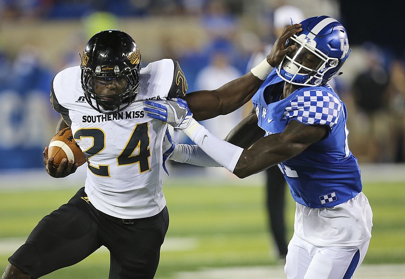 Southern Mississippi running back George Payne tries to keep out of the grip of Kentucky cornerback Chris Westry in the second half of an NCAA college football game Saturday, Sept. 3, 2016, in Lexington, Ky. Southern Mississippi won the game 44-35. (AP Photo/David Stephenson)