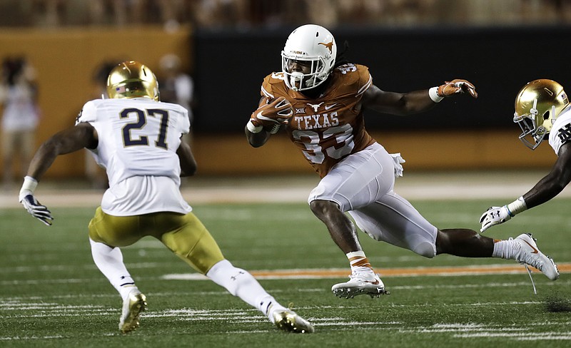 
              Texas running back D'Onta Foreman (33) runs from Notre Dame cornerback Julian Love (27) during the second half of an NCAA college football game, Sunday, Sept. 4, 2016, in Austin, Texas. (AP Photo/Eric Gay)
            