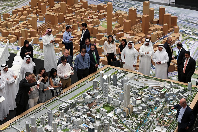 
              Journalists and Emirati officials listen to Morgan Parker, Chief Operating Officer of Dubai Holding, 1st left front row, as he explains over the architectural model of the “Jumeriah Central” development, a U.S. $ 20 billion project, during a press briefing in Dubai, United Arab Emirates, Sunday, Sept. 4, 2016. The company controlled by Dubai's ruler has unveiled plans for a vast mixed-use development that will create thousands of new homes and hotel rooms. (AP Photo/Kamran Jebreili)
            