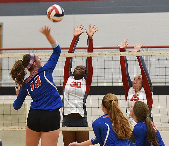 Cleveland's Morgan Moffett (13) prepares to slam the ball past Ooltewah's Cheyanne (30) and Aubbie Collake (15) in the second game Tuesday at Ooltewah.