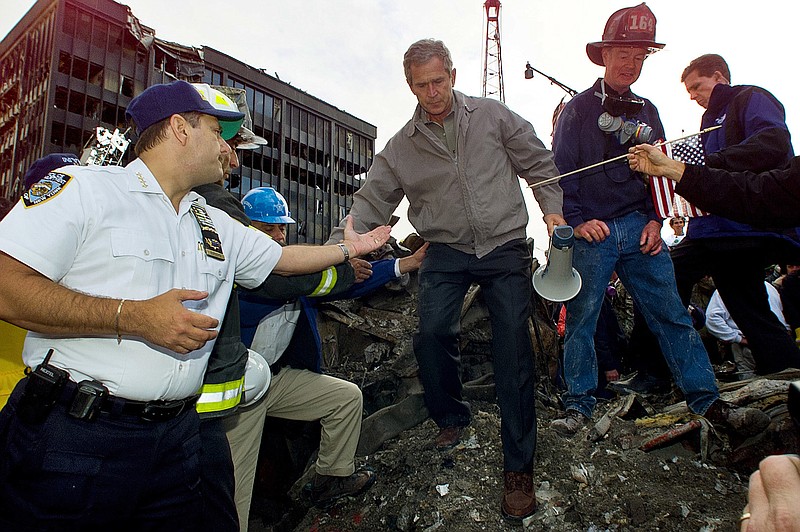 FILE - In this Friday, Sept. 14, 2001 file photo, Joseph Esposito, left, chief of department of the New York Police Department, offers help as President George W. Bush steps off of a pile of rubble after speaking at ground zero of the World Trade Center site in New York. Esposito, then the NYPD's top uniformed officer, was struck by "the camaraderie, the unity" of those days. (AP Photo/Doug Mills)