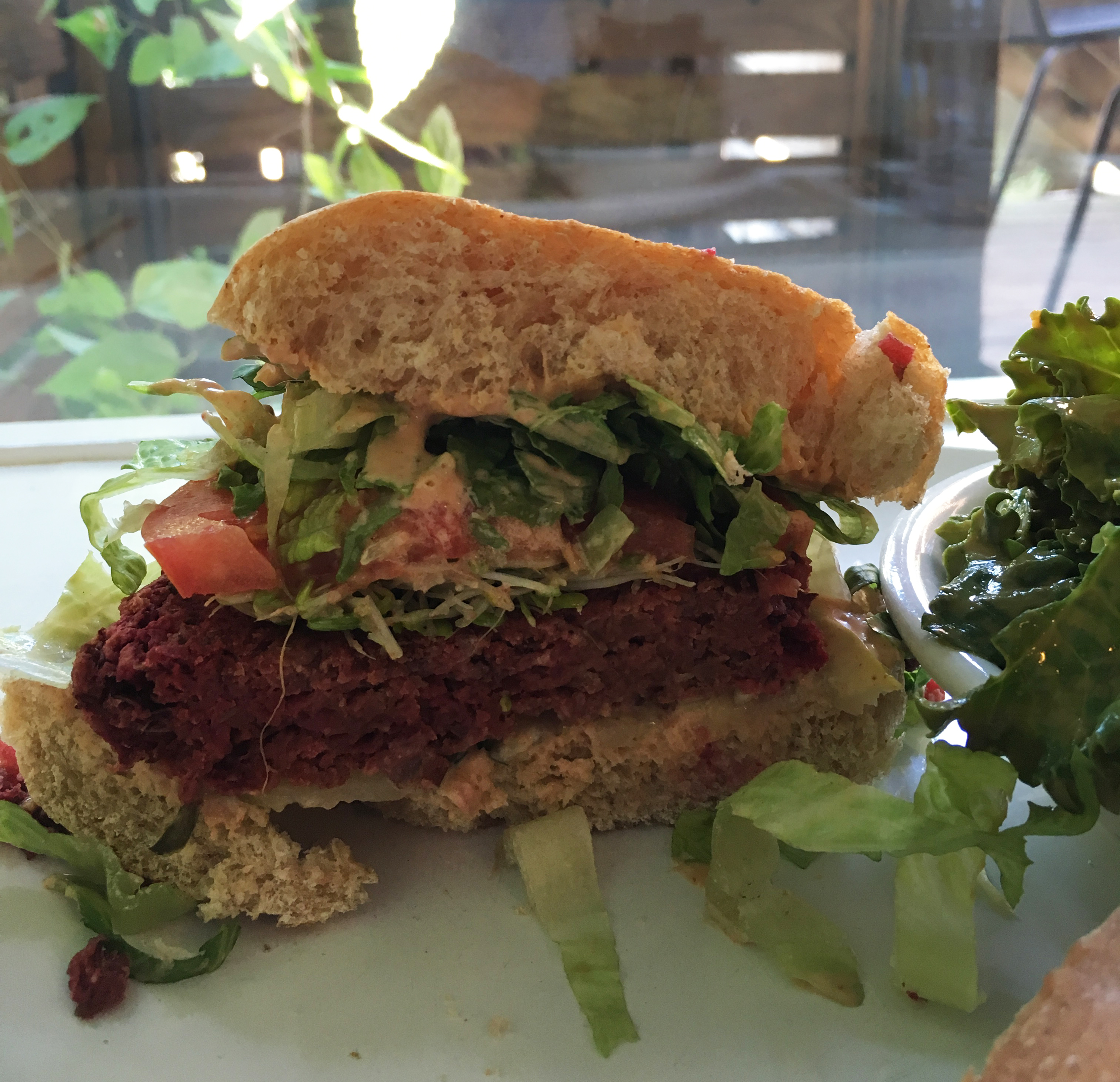 Cashew's Beet Burger comes with lettuce and tomato for topping. The side dish of garlicky kale is optional but is a perfect pairing with the mild burger.