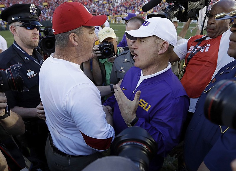 LSU coach Les Miles, right, talks to Wisconsin coach Paul Chryst after Wisconsin's 16-14 win this past Saturday at Lambeau Field in Green Bay, Wis. Miles' Tigers entered the game with a top-five ranking and plenty of optimism, but the unranked Badgers were undaunted.