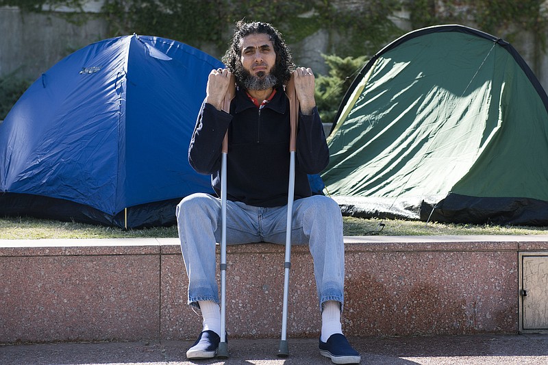 
              In this May 5, 2015 photo, former Guantanamo detainee Abu Wa'el Dhiab from Syria sits in front of the U.S. embassy while visiting former fellow detainees who were demanding financial assistance from the U.S., in Montevideo, Uruguay. Dhiab, who resettled in Uruguay, was briefly hospitalized Monday, Sept. 5, 2016, after becoming weak from a hunger strike. Dhiab is demanding that he be allowed to leave the South American country. Uruguay took in Dhiab and five other former Guantanamo prisoners for resettlement in 2014. (AP Photo/Matilde Campodonico)
            