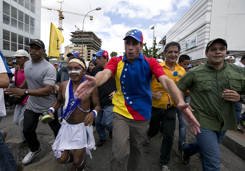 
              FILE - In this Sept 1, 2016 file photo, Venezuelan opposition leader Henrique Capriles takes part in the "taking of Caracas" march in Caracas, Venezuela. Capriles says he was harassed in a Margarita island airport for four hours by armed and hooded government supporters. The tense standoff ended after midnight Wednesday, Sept. 7,  when the supporters withdrew from an area close to baggage claim where they awaited Capriles.   (AP Photo/Ariana Cubillos, File)
            