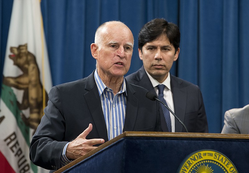 
              FILE - In this Wednesday, Aug. 24, 2016 file photo, Calif., Gov. Jerry Brown announced that he would sign a pair of environmental bills approved by the Legislature, during a news conference in Sacramento, Calif. At right, is Senate President Pro Tem Kevin de Leon, D-Los Angeles. Brown is set to extend the nation's most ambitious climate change law by another 10 years, charting a new goal to reduce carbon pollution. Brown chose an urban natural park on the edge of downtown Los Angeles as his setting to sign the legislation into law on Thursday, Sept. 8. (AP Photo/Rich Pedroncelli, File)
            