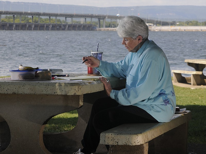 Marti Carelli-Gilbert says she hand-writes between two and four hours a day, four days a week, often at a picnic table near Chickamauga Dam.
