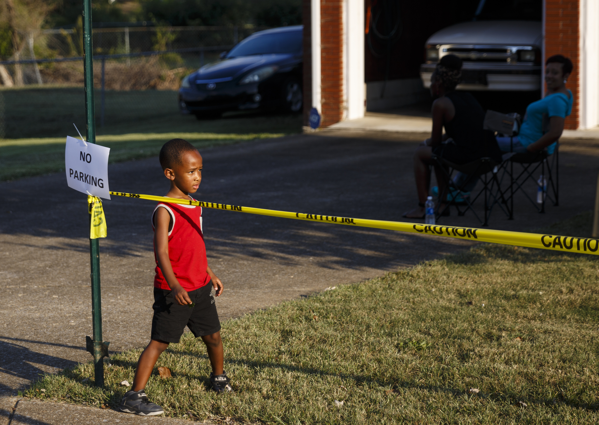 Joel Sims plays near a "No Parking" sign placed in front of a home nearby before a performance by artist Usher at Dalewood Middle School on Friday, Sept. 9, 2016, in Chattanooga, Tenn. The concert concluded a string of activities and benefits by the artist in his home town.
