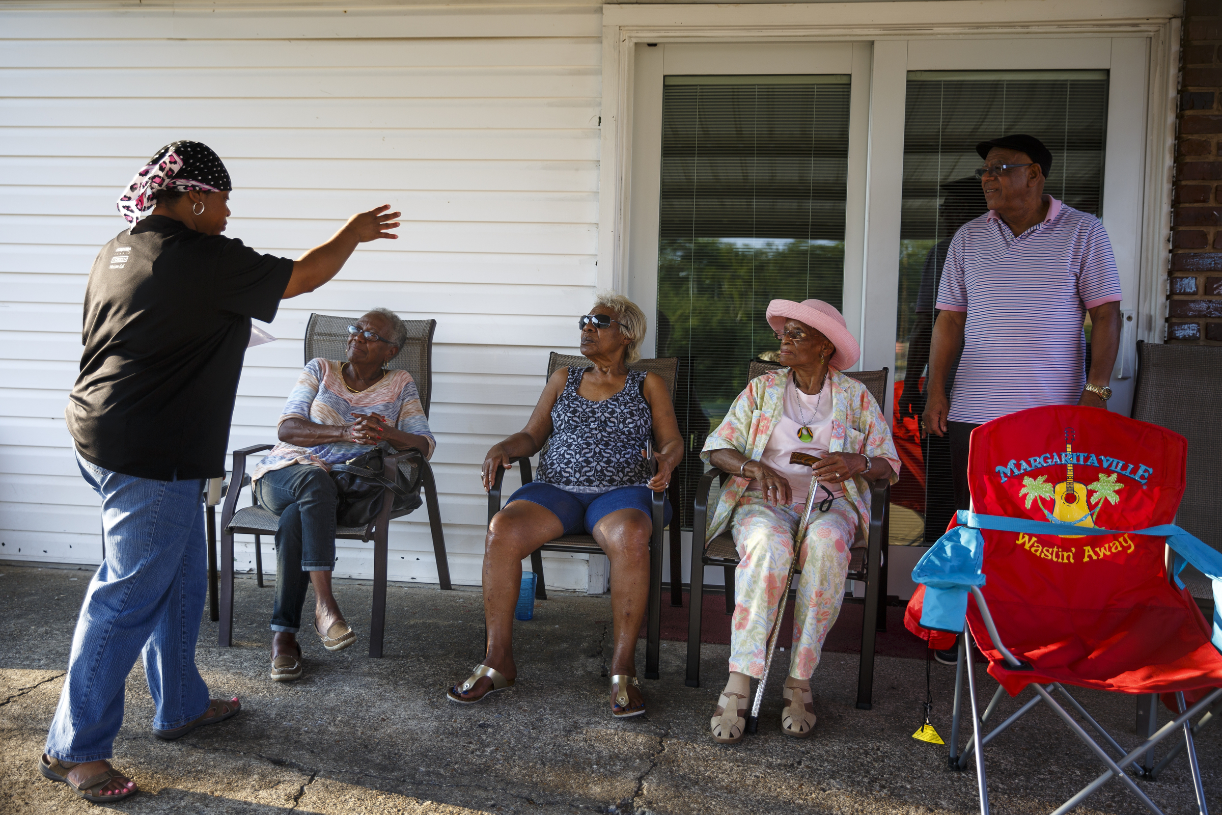 Neighborhood residents sit on their porch to watch a performance by artist Usher at Dalewood Middle School, his former school, from a distance on Friday, Sept. 9, 2016, in Chattanooga, Tenn. The concert concluded a string of activities and benefits by the artist in his home town.