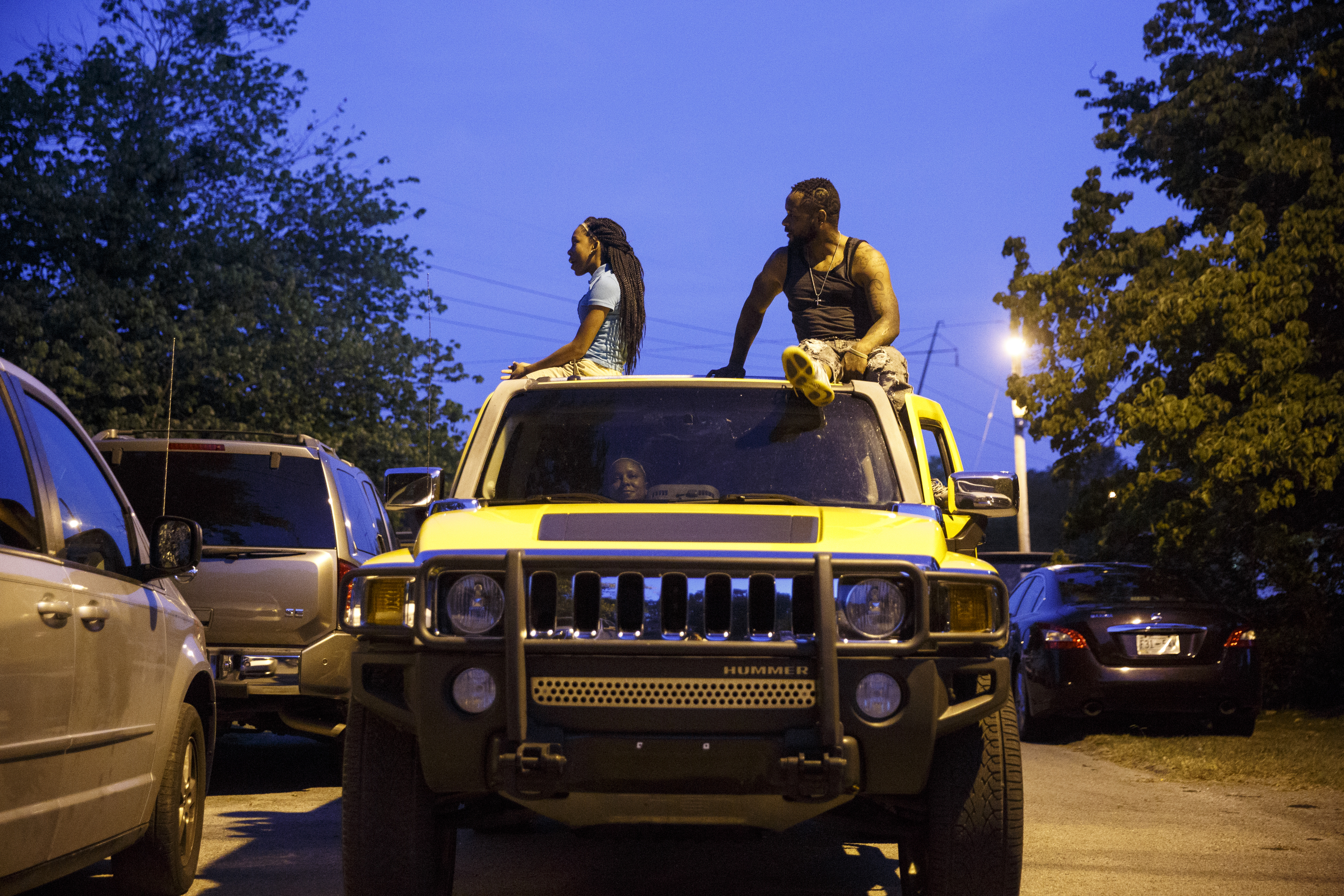 People sit on their vehicle to watch a performance by artist Usher at Dalewood Middle School, his former school, from outside the venue on Friday, Sept. 9, 2016, in Chattanooga, Tenn. The concert concluded a string of activities and benefits by the artist in his home town.