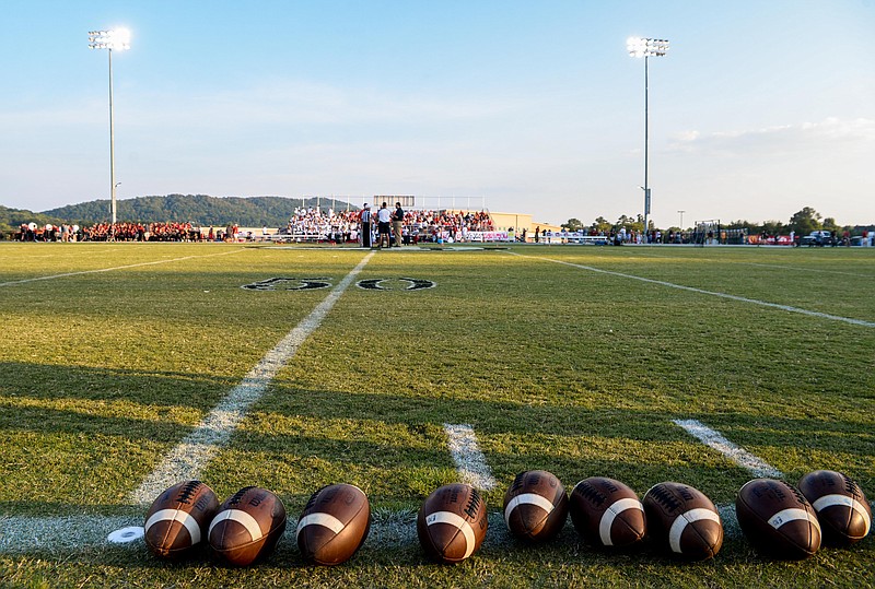 Footballs are lined up on the sideline as the coachs meet in the middle of the field before the game between the Ooltewah and East Hamilton on September 9, 2016.