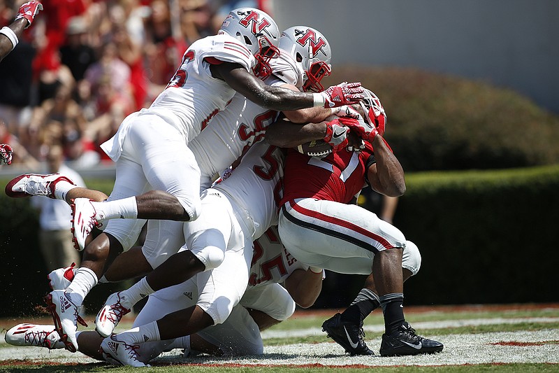 Georgia running back Nick Chubb (27) is tackled by Nicholls defensive back B.T. Sanders (26), defensive lineman Devin Simoneaux (95), and linebacker Hezekiah White (58) in the first half of an NCAA college football game Saturday, Sept. 10, 2016, in Athens, Ga. (AP Photo/Brett Davis)