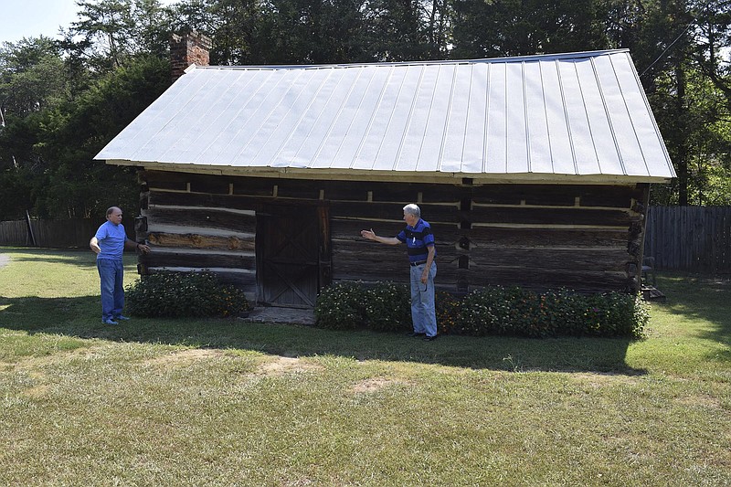 The Zachariah O'Neal home place in Trenton, Ga., is the target of preservation efforts to restore the cabin to the look it had when the settler's family first came to what would become Dade County. O'Neal raised 10 children in this tiny, two-room cabin. Here, Leroy Fanning, left, who has owned the site since 1977, and local artist Larry Dodson, who did a painting of the cabin as he envisioned it in its heyday, talk about restoration ideas for exterior and interior of the building.

