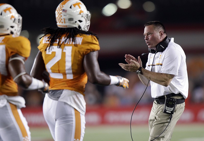 Tennessee head coach Butch Jones applauds players, including linebacker, Jalen Reeves-Maybin (21) as they come off the field during the first half of an NCAA college football game against Virginia Tech at Bristol Motor Speedway on Saturday, Sept. 10, 2016, in Bristol, Tenn. (AP Photo/Wade Payne)