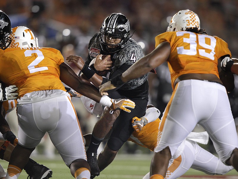 Virginia Tech quarterback Jerod Evans (4) runs the ball against Tennessee defenders Shy Tuttle (2) and Kendal Vickers (39) during the first half of an NCAA college football game at Bristol Motor Speedway on Saturday, Sept. 10, 2016, in Bristol, Tenn. (AP Photo/Wade Payne)