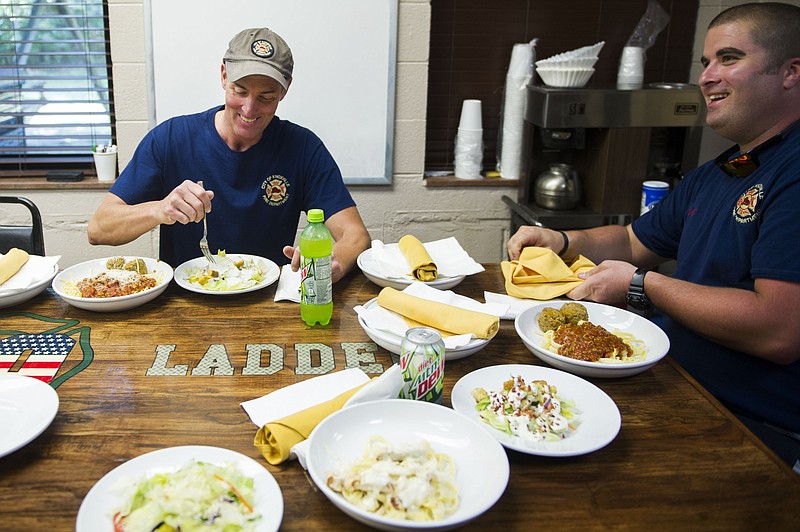 
              In this Monday, Sept. 5, 2016 photo, firefighters Robert Cheatham, left, and Andy Shockley enjoy lunch courtesy of a local Olive Garden restaurant in Knoxville, Tenn. Every year for the last decade and a half, Olive Garden restaurants around the country have delivered meals to first responders on Labor Day. For the last three years, Olive Garden No. 1092 has delivered a pasta to the fire station, less than a mile from the restaurant. (Caitie McMekin/Knoxville News Sentinel, via AP)
            