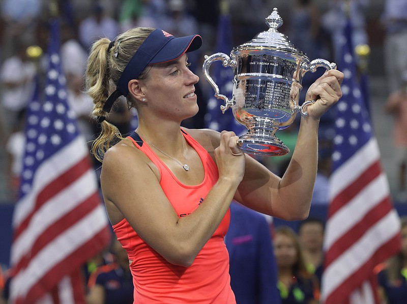 Angelique Kerber, of Germany, holds up the championship trophy after beating Karolina Pliskova, of the Czech Republic, to win the women's singles final of the U.S. Open tennis tournament, Saturday, Sept. 10, 2016, in New York. (AP Photo/Darron Cummings)