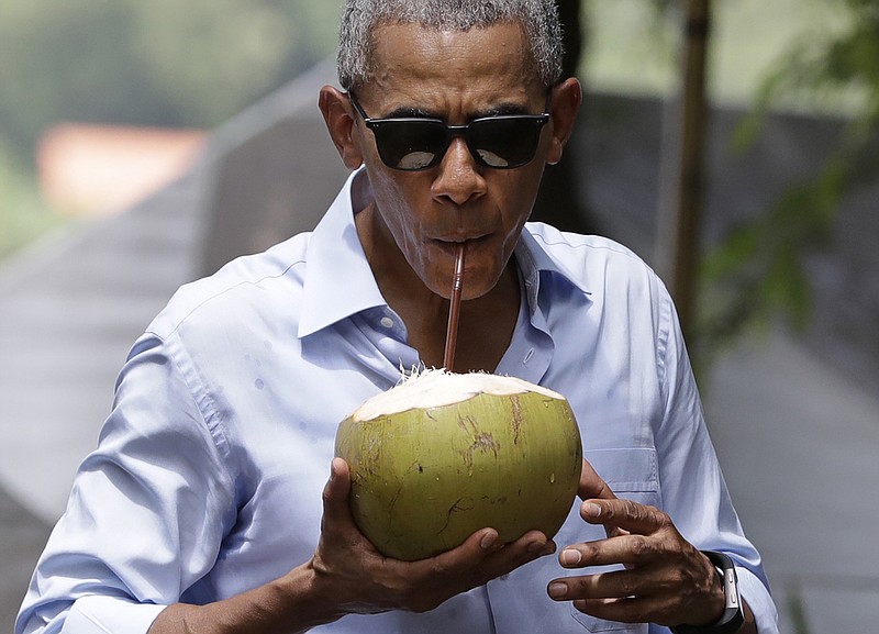 President Barack Obama drinks from a fresh coconut along the banks of the Mekong River in the Luang Prabang of Laos last week.