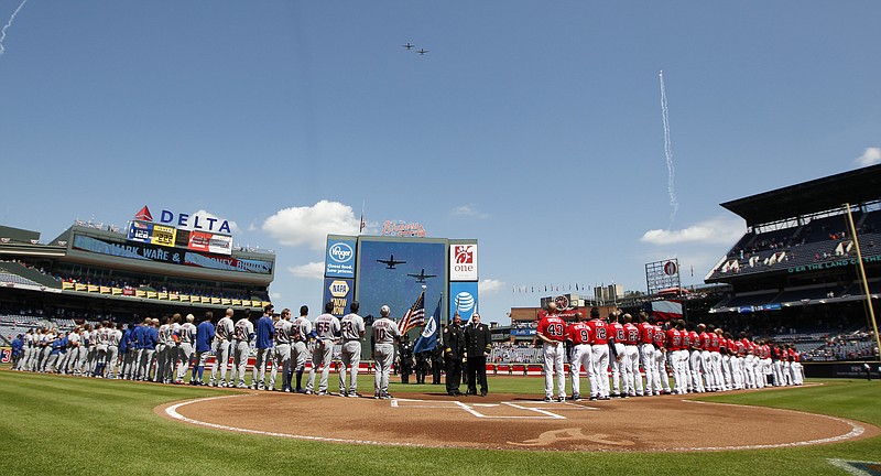 The Atlanta Braves and the New York Mets participate in a 9/11 commemoration as jets pass overhead before a baseball game in Atlanta Sunday, Sept. 11, 2016. (AP Photo/Tami Chappell)