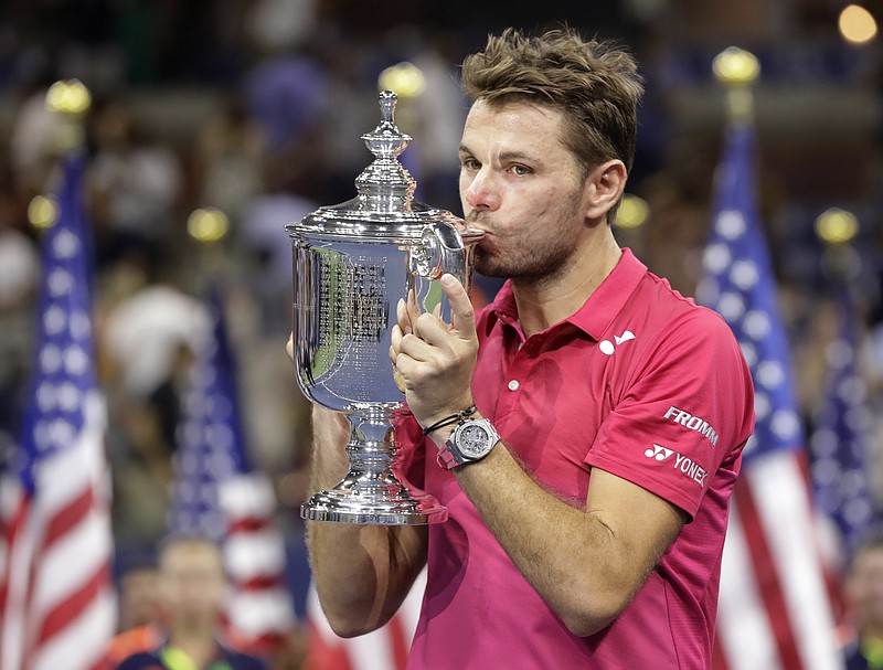 Stan Wawrinka, of Switzerland, holds up the championship trophy after beating Novak Djokovic, of Serbia, to win the men's singles final of the U.S. Open tennis tournament, Sunday, Sept. 11, 2016, in New York. (AP Photo/Darron Cummings)