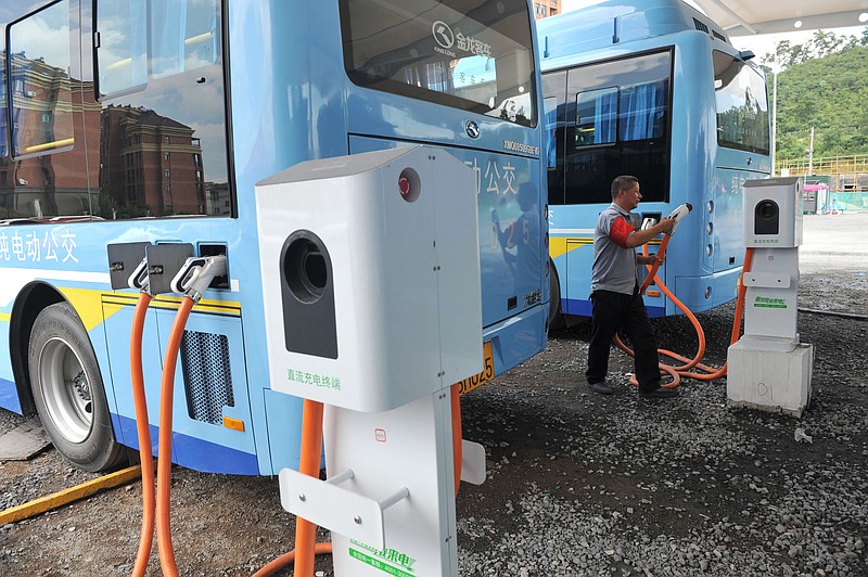 
              In this Friday, July 15, 2016, photo, a driver charges an electric bus made by King Long United Automotive Industry at a terminal in Lin'an city in eastern China's Zhejiang Province. China's electric vehicle industry, a flagship for Beijing's technology ambitions, has been rocked by scandal after five companies were caught collecting millions of dollars in subsidies for buses they never made. (Chinatopix via AP)
            