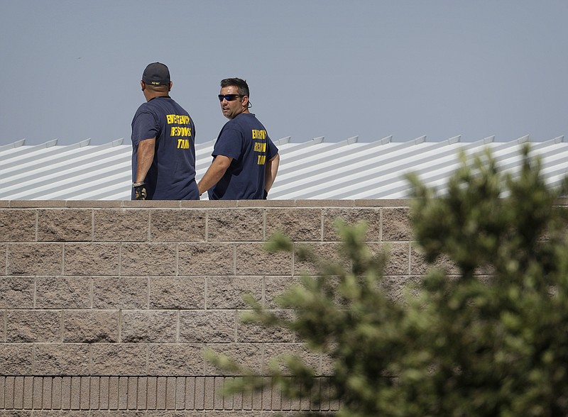 
              People walk on the roof of Walter Johnson Junior High School, Monday, Sept. 12, 2016, in Las Vegas. Investigators say they're puzzled by the significant amount of mercury found at the Las Vegas middle school, days after the neurotoxin was first discovered and forced students into a quarantine that lasted overnight. (AP Photo/John Locher)
            