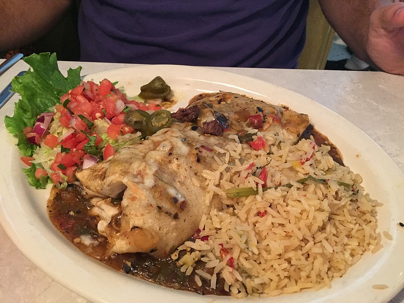 The Steak Burrito is a 12-inch monstrosity stuffed with grilled steak and cheese, topped with Hatch Green Chile sauce. It is served with green chile rice and charro beans (not pictured).