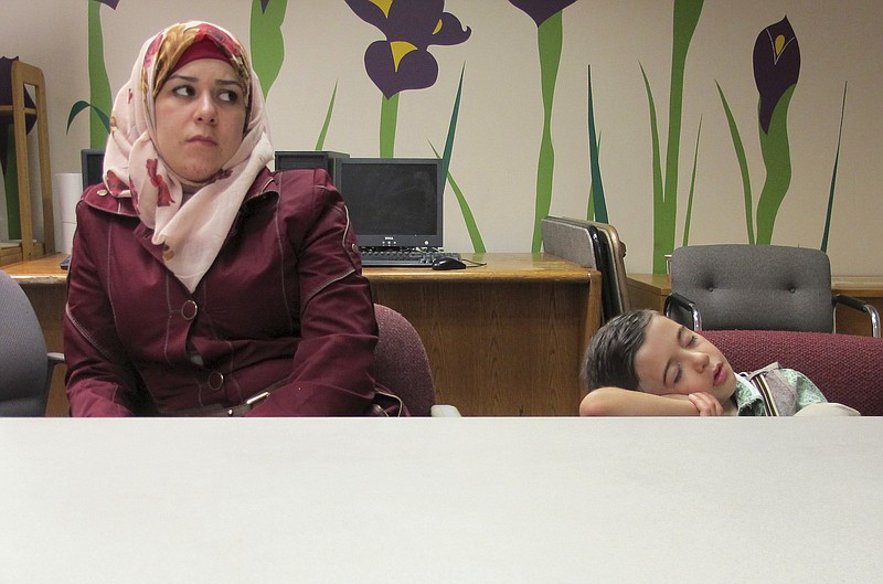 
              In this Friday, Sept. 2, 2016 photo, Syrian refugee Fatema, left, sits beside her sleeping 5-year-old son Ayham at the Integrated Refugee & Immigrant Services in New Haven, Conn. The family was diverted to Connecticut last year after Indiana Gov. Mike Pence said they were not welcome in that state. In their new home state, they have been received warmly by many, including Connecticut’s Democratic governor, but they say they also have faced difficulties with finding work and with discrimination. (AP Photo/Pat Eaton-Robb)
            
