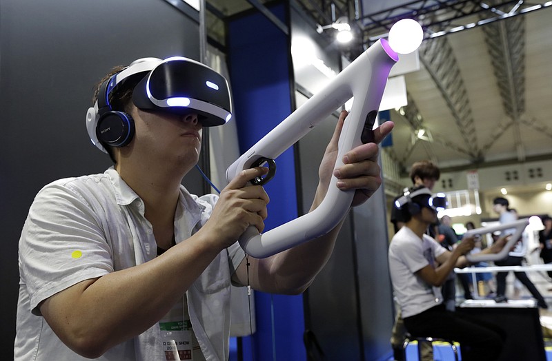 
              A visitor tries out a PlayStation VR headgear device at the Tokyo Game Show in Makuhari, near Tokyo, Thursday, Sept. 15, 2016. Virtual reality has arrived for real at the Tokyo Game Show, one of the world's biggest exhibitions for the latest in fun and games. (AP Photo/Eugene Hoshiko)
            