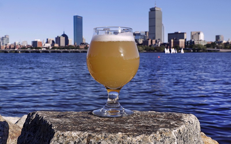 
              A glass of Castle Island Brewing Company "Chuck" beer, a dry hopped cream ale, rests on a rock along the bank of the Charles River, Thursday, Sept. 15, 2016, in Cambridge, Mass. Leading New England breweries are competing to see who can turn the questionable water of Boston's Charles River into the tastiest suds. (AP Photo/Charles Krupa)
            