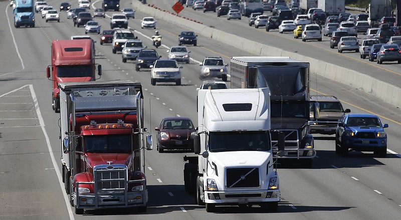 In this Wednesday, Aug. 24, 2016, file photo, truck and automobile traffic mix on Interstate 5, headed north through Fife, Wash., near the Port of Tacoma. Truckers are warning that a government plan to electronically limit the speed of tractor-trailer rigs will lead to highway traffic jams and even an increase in deadly run-ins with cars allowed to travel at faster speeds. (AP Photo/Ted S. Warren, File)