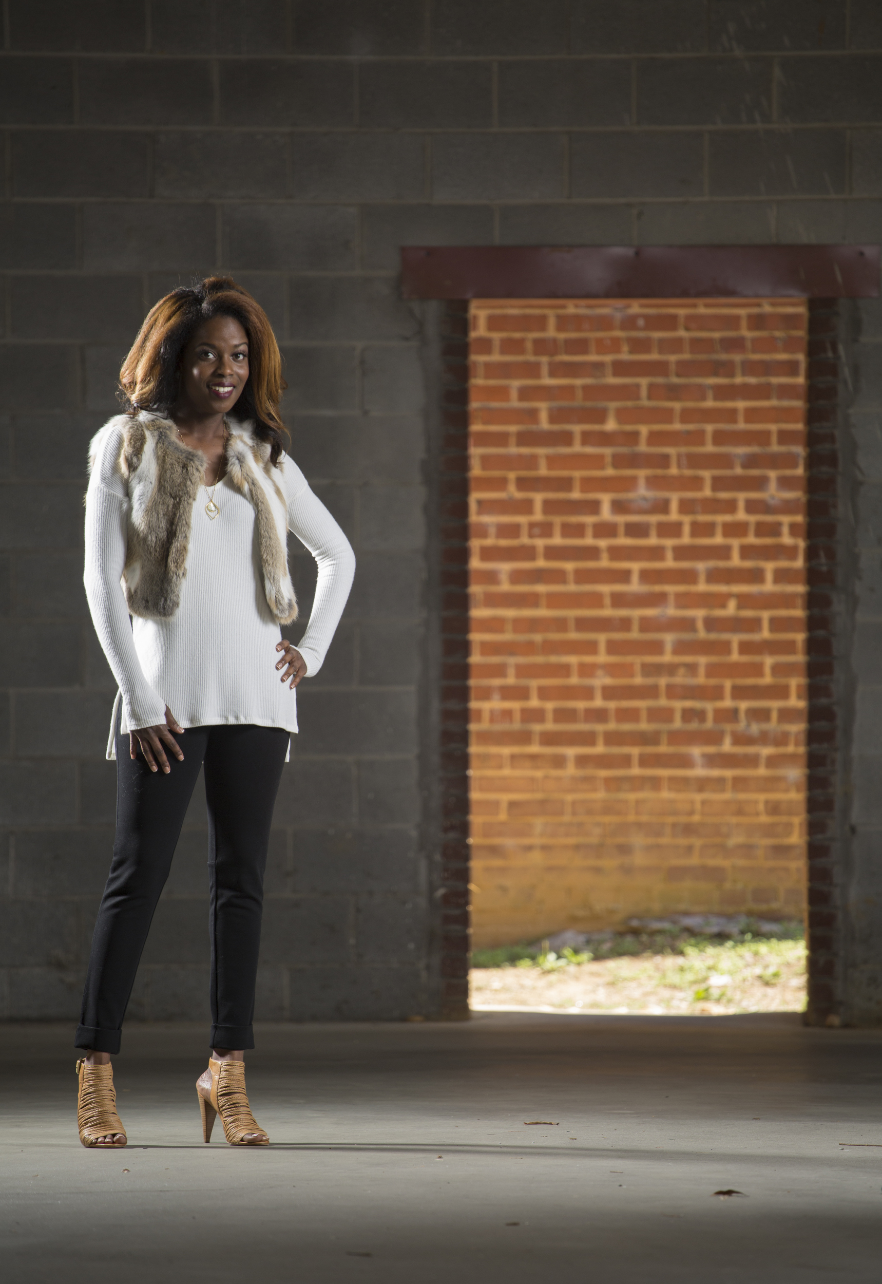Staff Photo by Dan Henry / The Chattanooga Times Free Press- 9/13/16. Lorean Mays models fall fashion outfits styled by Suzanne West, owner of Frankie & Julien's, located in North Chattanooga. Mays is wearing a Lilla P. black cropped cuffed pant, a Michael Stars ribbed knit top in winter white, 525 America Luxe real fur cropped vest in natural and a gold necklace with pendant from Frolick Jewelry.