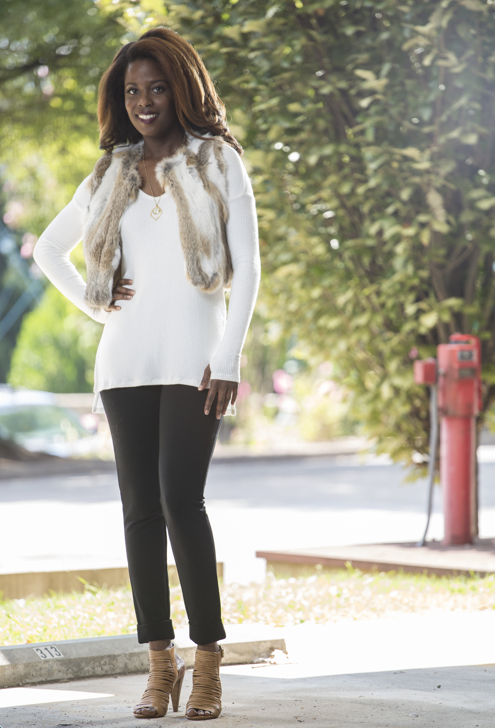 Staff Photo by Dan Henry / The Chattanooga Times Free Press- 9/13/16. Lorean Mays models fall fashion outfits styled by Suzanne West, owner of Frankie & Julien's, located in North Chattanooga. Mays is wearing a Lilla P. black cropped cuffed pant, a Michael Stars ribbed knit top in winter white, 525 America Luxe real fur cropped vest in natural and a gold necklace with pendant from Frolick Jewelry.