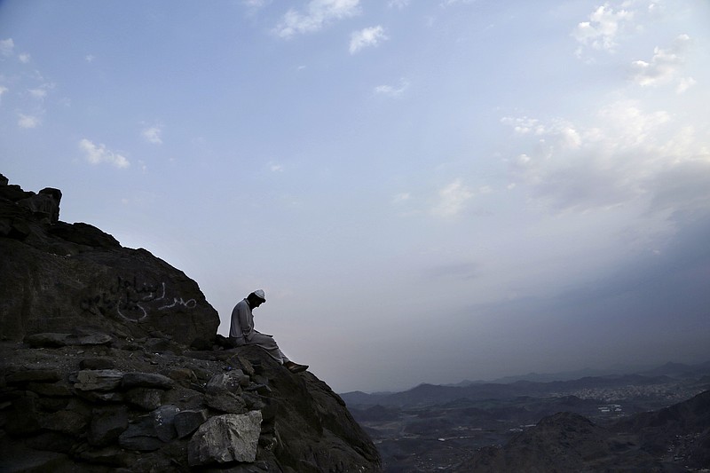 
              In this Friday, Sept. 9, 2016 photo, a Pakistani man living near Hira cave reads before sunrise on Noor Mountain, where the Prophet Muhammad received his first revelation from God to preach Islam, on the outskirts of Mecca, Saudi Arabia. It is one of Islam’s most important historical sites _ the cave where the Prophet Muhammad spent time in seclusion, contemplation and self-reflection.(AP Photo/Nariman El-Mofty)
            